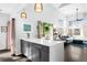 Open kitchen with island, quartz countertops, and seamlessly flowing into a sun-drenched living room at 13706 Legend Trail # 104, Broomfield, CO 80023