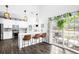 Bright kitchen with white cabinets, breakfast bar, stainless steel appliances, and patio access at 13706 Legend Trail # 104, Broomfield, CO 80023