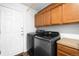 Laundry room with a modern washer and dryer set, storage cabinets, and a door at 13706 Legend Trail # 104, Broomfield, CO 80023