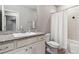 Bathroom with granite countertops, white cabinets, shower with tile walls, and sink at 18036 E 99Th Ave, Commerce City, CO 80022