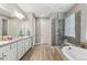 Bathroom featuring double sinks, shower, soaking tub, and neutral color palette at 18036 E 99Th Ave, Commerce City, CO 80022