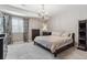 Comfortable main bedroom with neutral gray walls, carpet, chandelier, large dresser, and closet at 18036 E 99Th Ave, Commerce City, CO 80022