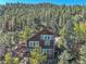 An aerial view of a mountain home featuring a deck and beautiful forest views, perfect for nature lovers at 31324 Kings Vly, Conifer, CO 80433