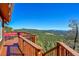 Deck area features stunning mountain views, red outdoor seating and a wooded railing at 31324 Kings Vly, Conifer, CO 80433