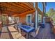 Outdoor dining set on a spacious wooden deck perfect for entertaining with beautiful wood beam ceiling at 31324 Kings Vly, Conifer, CO 80433