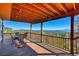 Covered deck features a dining table, a porch swing and great view of wooded mountains at 31324 Kings Vly, Conifer, CO 80433