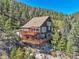 Stunning three-story mountain home with multiple wooden decks on a picturesque, wooded lot with beautiful views at 31324 Kings Vly, Conifer, CO 80433