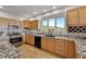 Well-lit kitchen features granite counters, stainless appliances, wood cabinets and a view to the outside at 31324 Kings Vly, Conifer, CO 80433
