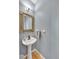 Stylish powder room with a pedestal sink, decorative mirror and light fixture at 31324 Kings Vly, Conifer, CO 80433