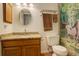 Bathroom boasts a vanity, commode, framed mirror, and a shower-tub with a decorative curtain at 23634 Pondview Pl # B, Golden, CO 80401