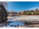 Scenic frozen pond view with bridge and surrounding trees, creating a winter wonderland atmosphere at 23634 Pondview Pl # B, Golden, CO 80401