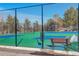 Exterior image of tennis courts surrounded by a fence and trees, offering an active lifestyle at 23634 Pondview Pl # B, Golden, CO 80401