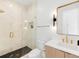 Modern bathroom features a glass-enclosed shower with black tile floor and gold fixtures at 1 S Forest St, Denver, CO 80246