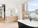 A luxurious bathroom features a soaking tub, modern vanity, and a large window at 1 S Forest St, Denver, CO 80246