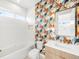 Stylish bathroom featuring bold wallpaper, a modern vanity, and a soaking tub with white tile at 1 S Forest St, Denver, CO 80246