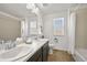 Bathroom featuring double sinks, dark cabinets, great natural light, and shower-tub combo at 9335 Dunraven Loop, Arvada, CO 80007