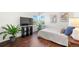 Bright bedroom with wood floors, large windows, stylish decor, and modern TV at 9335 Dunraven Loop, Arvada, CO 80007