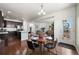 Bright dining area with a wood table, an open layout, and hardwood floors leads to a modern kitchen at 9335 Dunraven Loop, Arvada, CO 80007