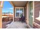 Cozy front porch with a wicker chair, stone accents, and view of the neighborhood at 9335 Dunraven Loop, Arvada, CO 80007