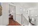 Upper level hallway with hardwood floors, white railing, and natural light at 9335 Dunraven Loop, Arvada, CO 80007
