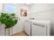 A bright laundry room with modern white washer and dryer and nice natural light at 9335 Dunraven Loop, Arvada, CO 80007