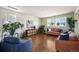 Bright living room with hardwood floors, stylish furniture, and large windows showcasing scenic mountain views at 9335 Dunraven Loop, Arvada, CO 80007