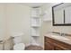 Small bathroom with toilet, sink, and corner shelves at 14190 E Temple Dr # O-04, Aurora, CO 80015