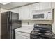 Kitchen with microwave, stove, and refrigerator at 14190 E Temple Dr # O-04, Aurora, CO 80015