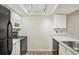 View of kitchen with white cabinets and black appliances at 14190 E Temple Dr # O-04, Aurora, CO 80015