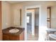 Neutral-toned bathroom featuring a single sink vanity and doorway leading to a bedroom with wood floors at 11595 Pass Me By Rd, Strasburg, CO 80136