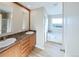 Bright bathroom with double sinks, wood cabinets, granite countertops, and a bathtub at 11595 Pass Me By Rd, Strasburg, CO 80136