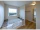 Inviting bathroom with a soaking tub next to a window and walk-in closet at 11595 Pass Me By Rd, Strasburg, CO 80136