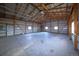 Vast garage featuring a concrete floor, metal walls, and a high ceiling with exposed wooden beams at 11595 Pass Me By Rd, Strasburg, CO 80136