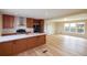 Bright kitchen area featuring wood cabinets, breakfast bar, stainless steel appliances, and laminate floors at 11595 Pass Me By Rd, Strasburg, CO 80136
