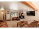 Spacious living room featuring a wood-burning stove and large TV at 28268 Shadow Mountain Dr, Conifer, CO 80433