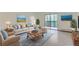 Bright living room with a plush sofa, blue accent rug, and sliding glass doors to a balcony at 6960 E Girard Ave # 105, Denver, CO 80224