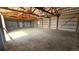 A barn interior with metal walls, concrete floor, exposed beams, and multiple garage doors at 2840 Wagner St, Strasburg, CO 80136