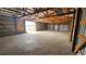 A spacious barn interior with a concrete floor, exposed beams, and multiple garage doors at 2840 Wagner St, Strasburg, CO 80136