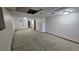 Unfinished basement with carpeted floors, white walls, drop ceiling, and doorway to another room at 2840 Wagner St, Strasburg, CO 80136