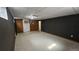 Basement room featuring neutral carpet, dark painted accent wall, and multiple doorways at 2840 Wagner St, Strasburg, CO 80136