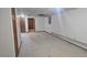 Unfinished basement with carpeted floors, stairs to upper level, and doorway to another room at 2840 Wagner St, Strasburg, CO 80136