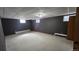 Finished basement with dark gray walls, carpeted floors, drop ceiling, and window at 2840 Wagner St, Strasburg, CO 80136