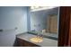 Bathroom vanity and mirror with view into the shower at 2840 Wagner St, Strasburg, CO 80136