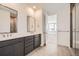 Modern bathroom with a double vanity, granite countertops, modern fixtures, and a glass-enclosed shower at 635 Twilight St, Erie, CO 80516