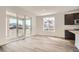 Bright living area featuring hardwood floors, white walls, sliding glass doors to the outside, and modern trim at 635 Twilight St, Erie, CO 80516