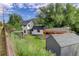 Aerial view of a home featuring a dark gray roof, shed, carport, and mature landscaping at 3429 Avenue D, Kittredge, CO 80457
