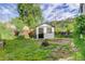 View of backyard featuring a shed with a black door and window surrounded by a green, lush yard at 3429 Avenue D, Kittredge, CO 80457