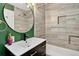 Stylist bathroom with a modern sink, decorative mirror, tiled shower and integrated storage niche at 3429 Avenue D, Kittredge, CO 80457