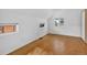 A bedroom has light walls and wood floors with two windows that bring in plenty of natural light at 3429 Avenue D, Kittredge, CO 80457