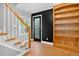 Inviting entryway with wood stairs, a black door, and a built-in wooden bookcase adds architectural detail at 3429 Avenue D, Kittredge, CO 80457